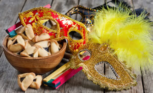 Hamantaschen cookies or Haman's ears, noisemaker and carnival masks for Purim celebration (jewish holiday).