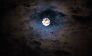 Mysterious dark night sky with full moon and clouds